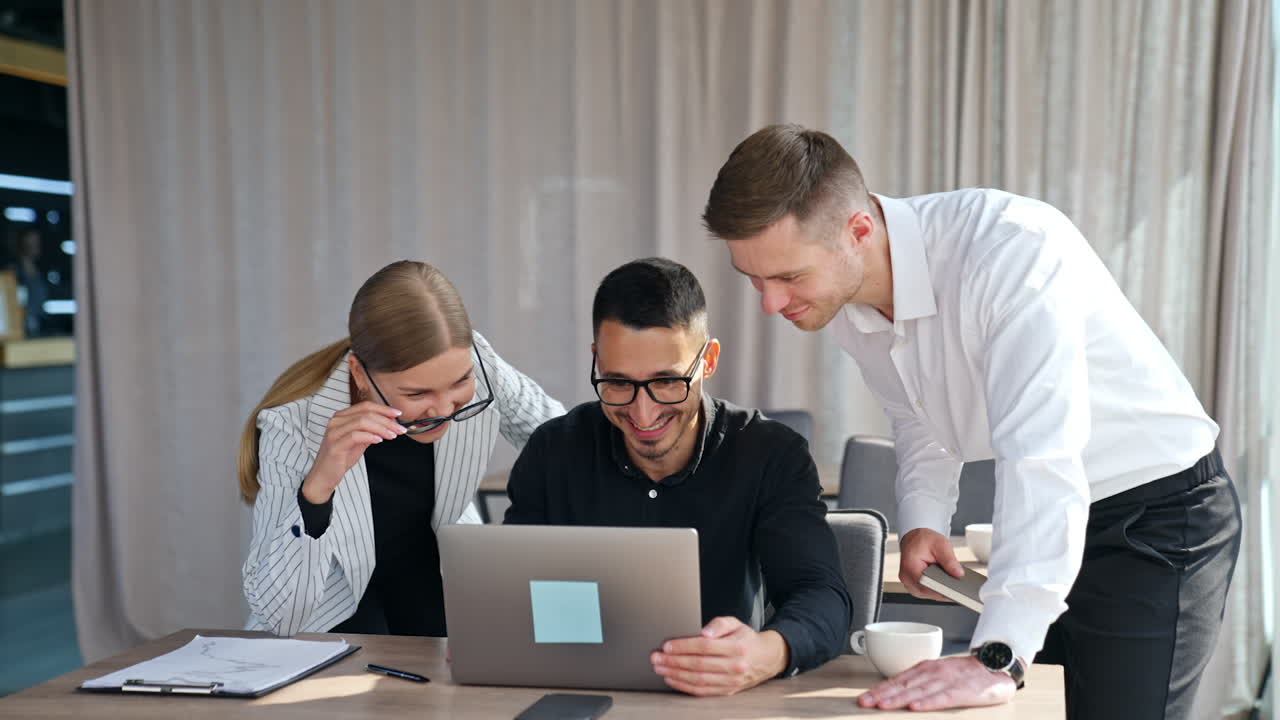 Co-working young office team looking at computer screen. Employees ...