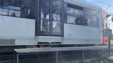 Tram-in-Germany-in-nice-weather-moves-towards-the-camera-with-felt-in-the-background