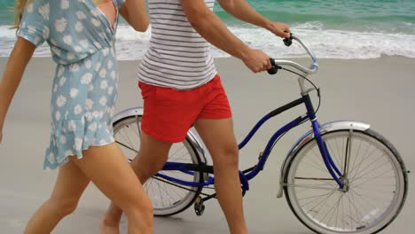 Seitenansicht-Eines-Kaukasischen-Paares,-Das-Mit-Dem-Fahrrad-Am-Strand-Spaziert,-4k