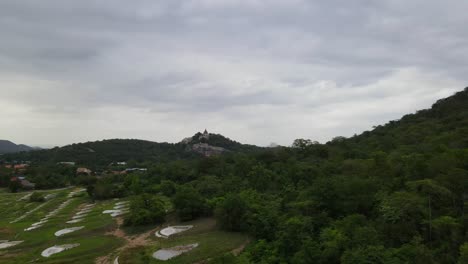 an aerial footage sliding to the left revealing wat phra phutthachai and a chinese cemetery, saraburi, thailand.