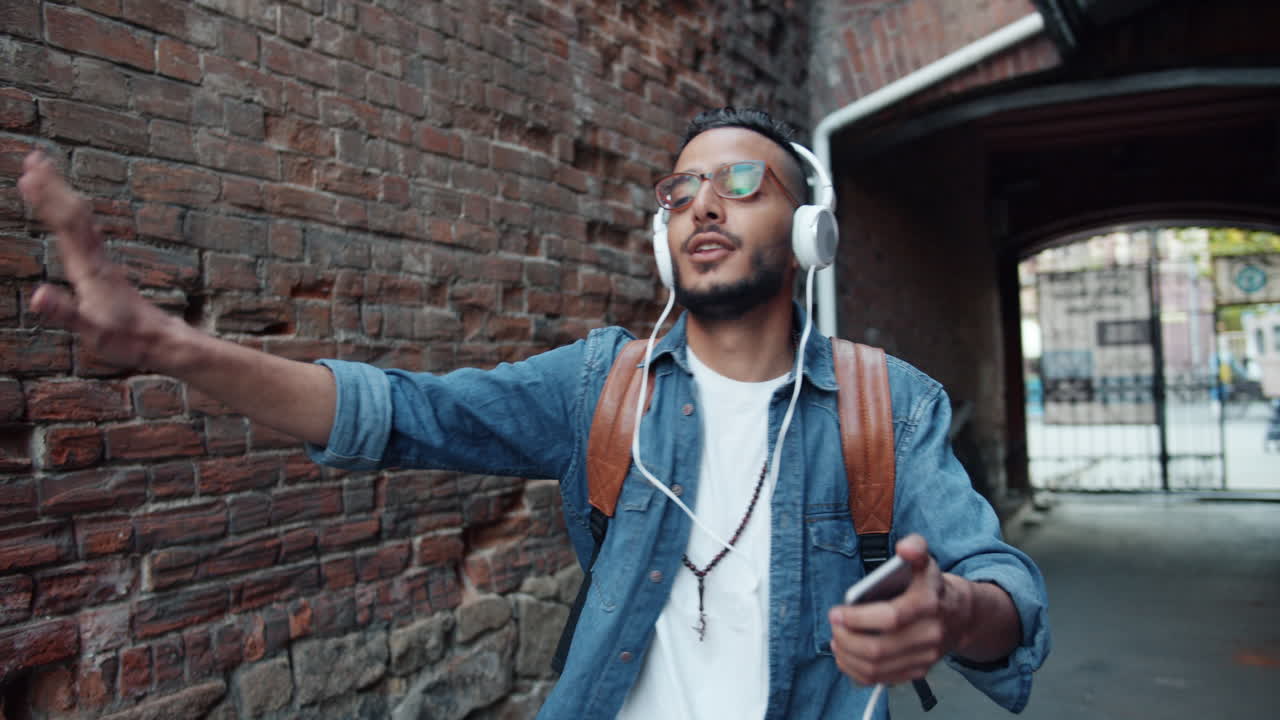 Man Walking Down a City Alleyway Listening to Music