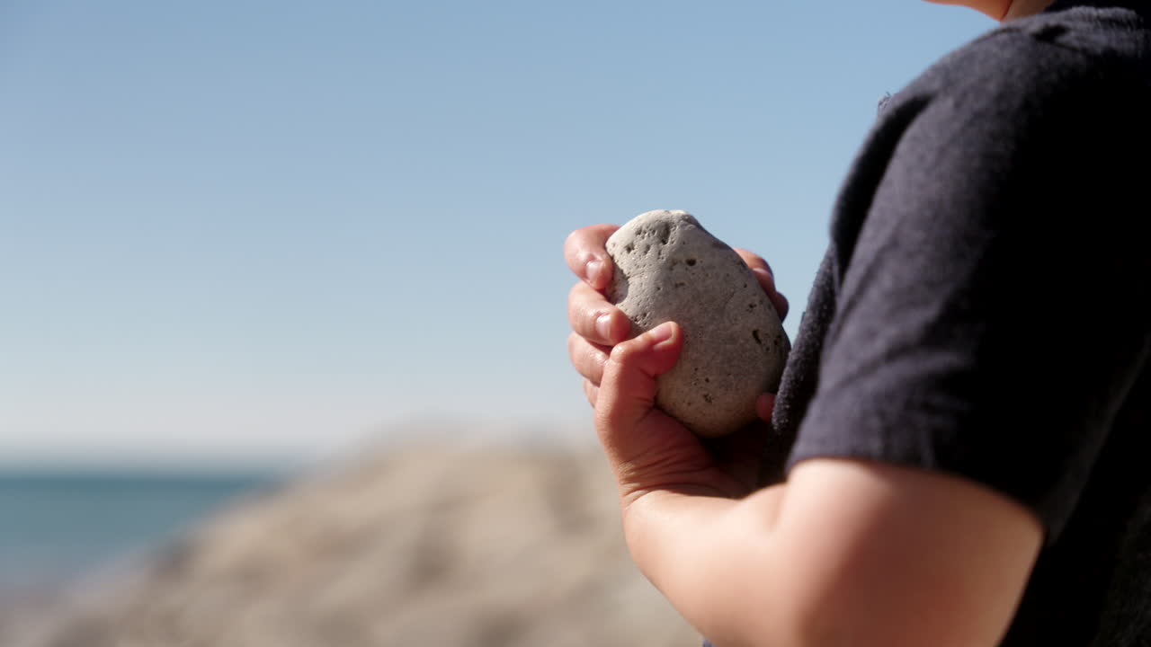 물  에 바위 를 들고 있는 소년
