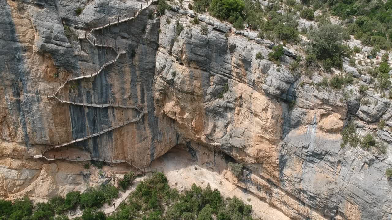 vistas aéreas del cañón de mont-rebei con los acantilados, escaleras en las paredes, el lago y el camino por el cañón