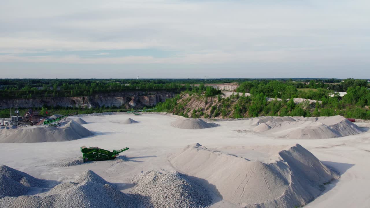 heavy duty machineries on site around Pile of construction gravel next to office and scale house