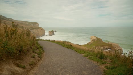 walking down a paved path along the side of a hill in new zealand