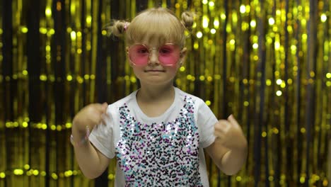 Child-kid-dancing,-celebrating-victory,-fooling-around.-Girl-posing-on-background-with-foil-curtain