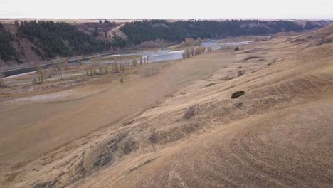 Aerial:-Game-trails-cross-dry-grass-hillside-in-prairie-river-valley
