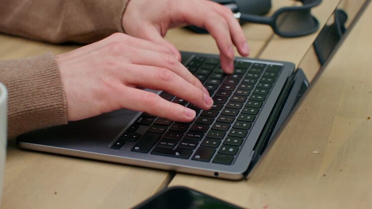 Person arbeitet im Freien am Laptop