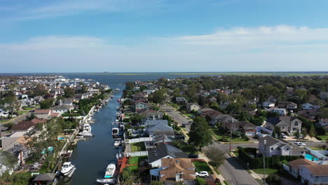 An-aerial-drone-shot-over-a-park,-leading-to-a-channel,-heading-out-to-East-Bay-on-Long-Island,-NY