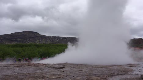 iceland's famous strokkur geysir geyser erupts with tourists watching