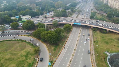 aerial drone shot capturing the complex road infrastructure of delhi, where multiple flyovers intersect with packed traffic below.
