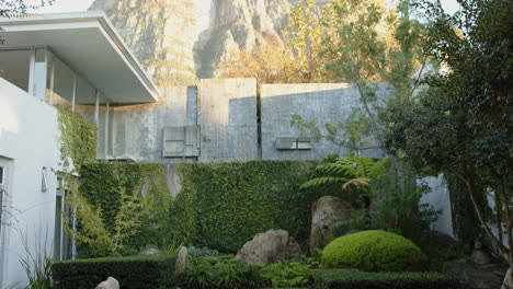 modern house with lush garden and mountain view in background, serene setting, copy space