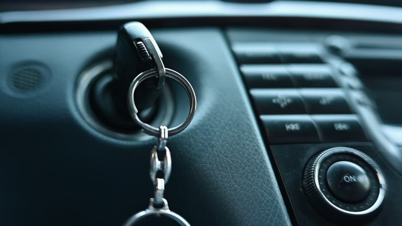 Close up of car keys in ignition with music player display board