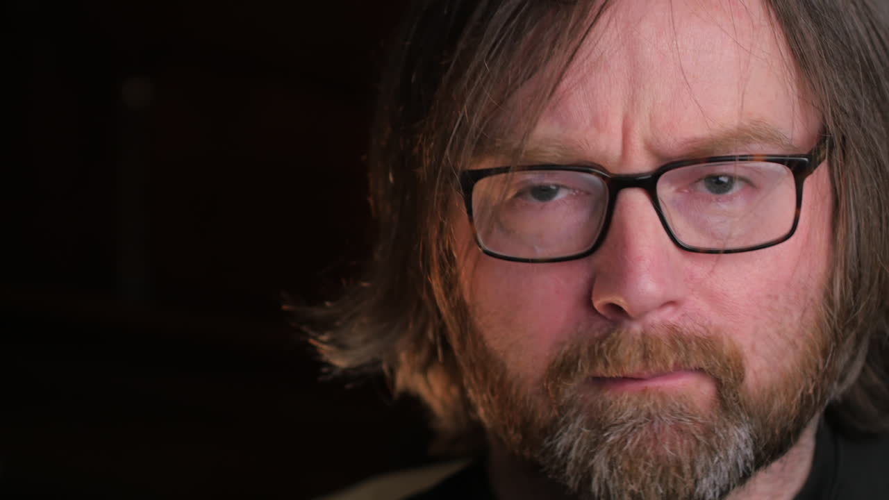 expresiones dudosas y determinadas de hombre barbudo con fondo negro, cerrar