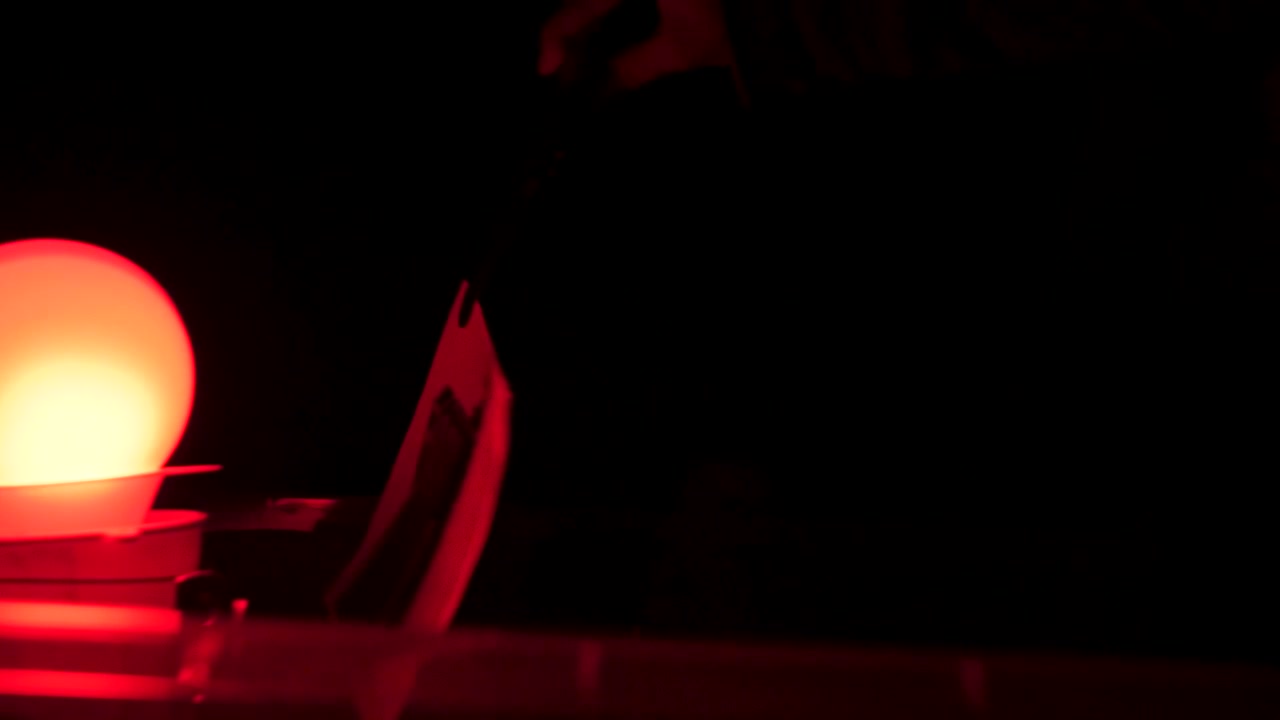 Immagine in luce rossa di una mano su un documento
