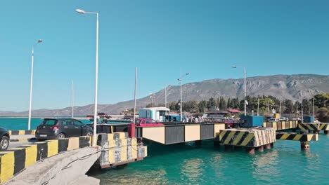cars crossing a floating bridge over turquoise water with mountains in the background