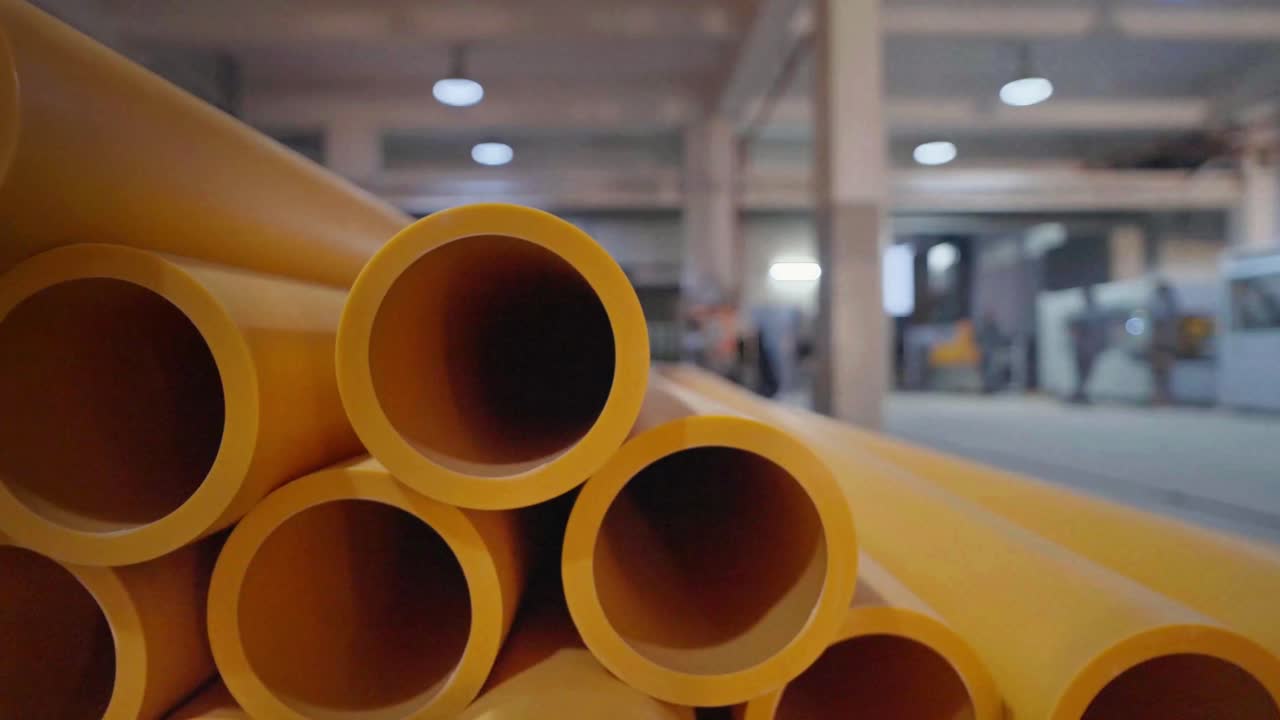 Nærbilde av ferdige gule rør i en PVC-rørfabrikk i Karachi, Pakistan. Innendørs utsikt.