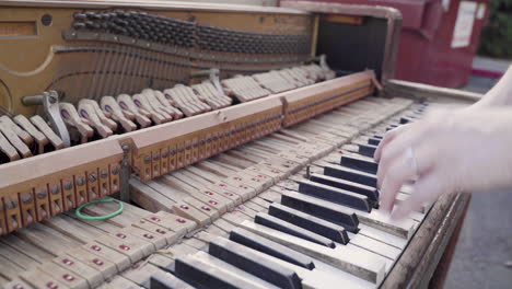 someone breaking a key off of an old piano and putting it back