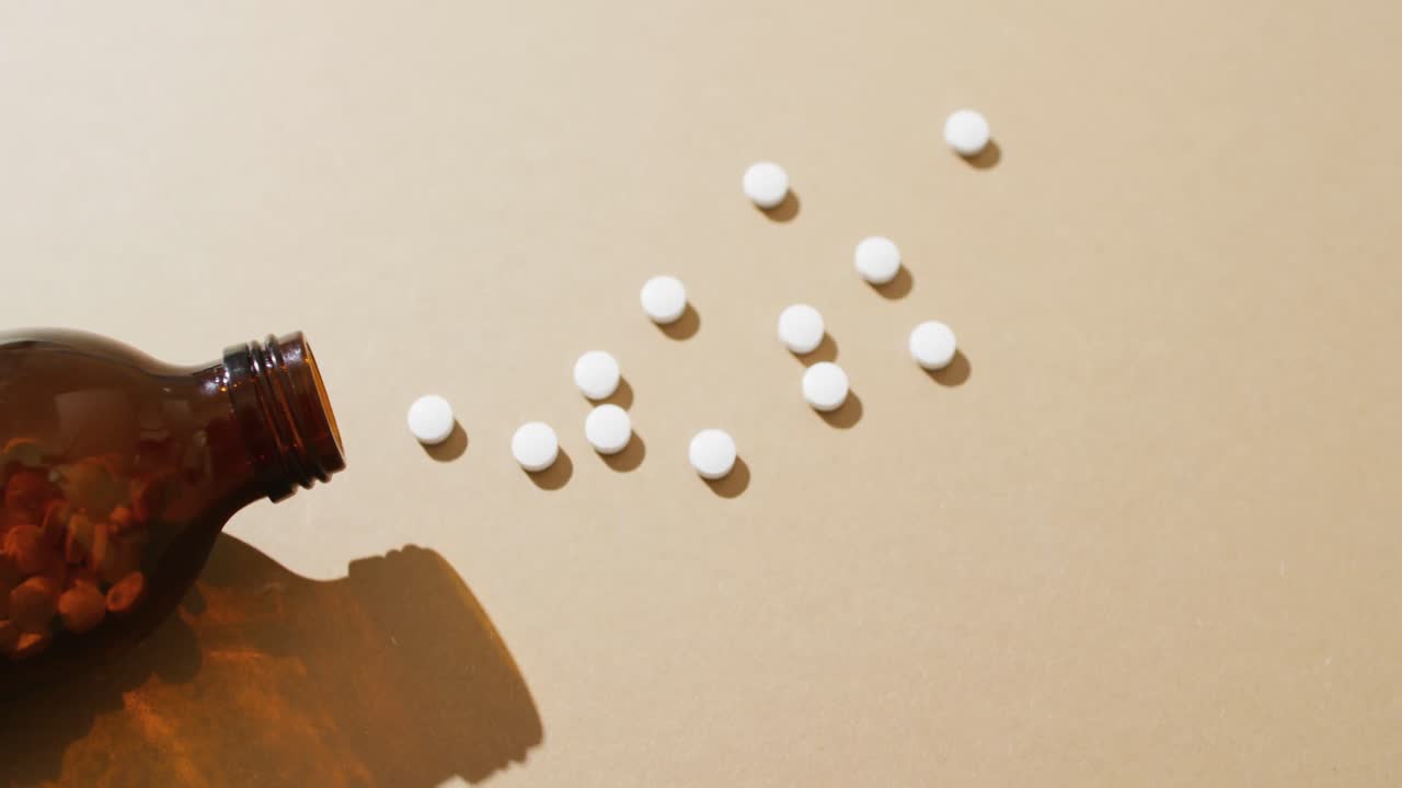 복사 공간과 함께 갈색 배경에  ⁇  알약을 흘리는 갈색 병의 비디오