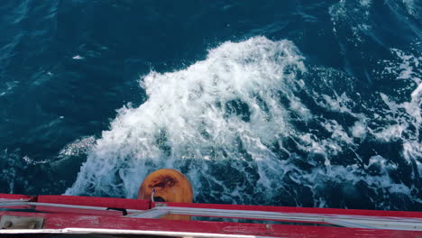 mirando hacia abajo desde el lado de un carguero con el agua fluyendo por delante