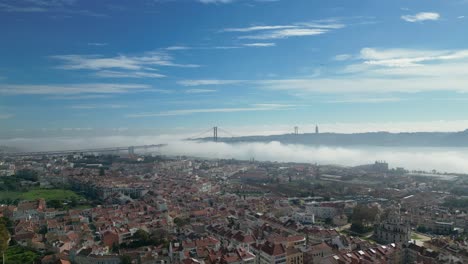 morning mist blankets the tagus river on a sunny day, with the silhouette of christ the king in the background, creating a serene and atmospheric scene