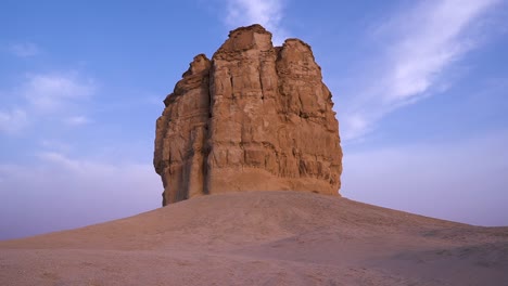 natural sandstone cliff in middle of desert isolated on blue sky, static view