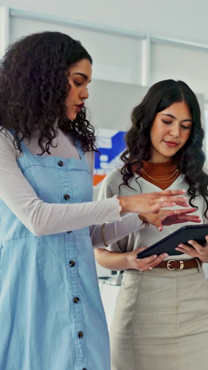 Due donne professioniste che collaborano su un tablet in ufficio