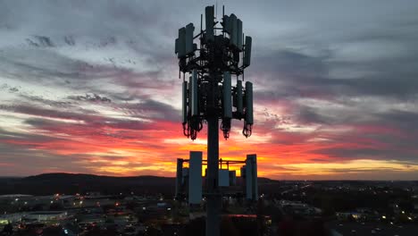 Cell-phone-tower-at-night-against-bright-sunset-sky-in-America