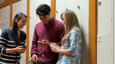 estudiantes que usan teléfonos inteligentes en el vestuario