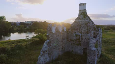 la llamarada del sol desde la puesta del sol iluminada en el castillo de terryland en el río corrib, galway, irlanda