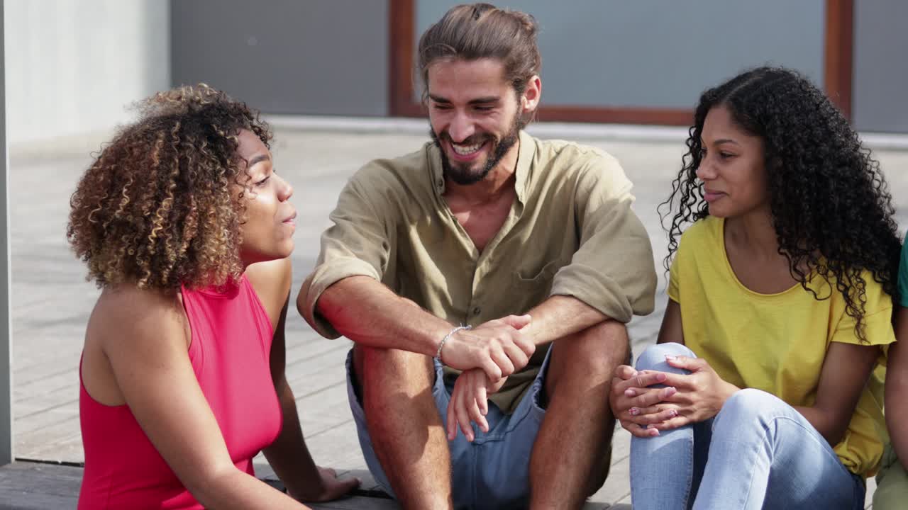 jóvenes amigos felices sentados al aire libre