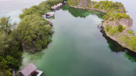 aerial pull back revealing karstic cliffs of rufas lagoon in indonesia