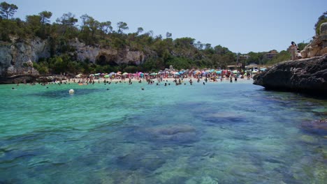 mallorca: beach side view of resort in cala liombards on majorca island, spain, europe | crowded beach swimming