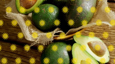 yellow starburst animation over avocados in basket on wooden surface