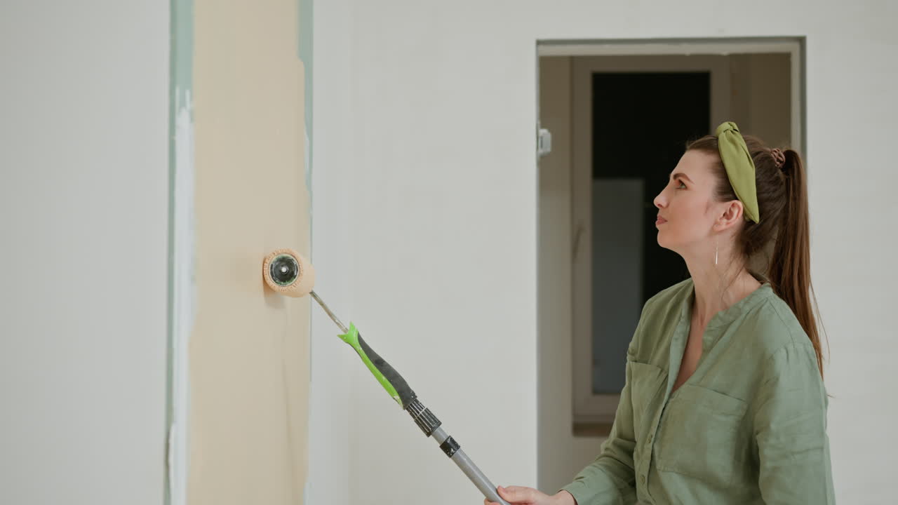 Una mujer pintando una pared.