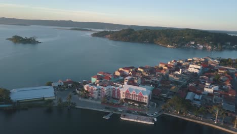 beautiful aerial drone shot of flores island bridge in the middle of lake peten itza, guatemala