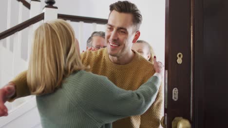 Video-of-happy-caucasian-husband-and-wife-hugging-with-senior-parents-at-their-home