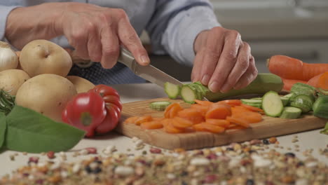 woman preparing vegan vegetarian meal, cutting vegetables zucchini