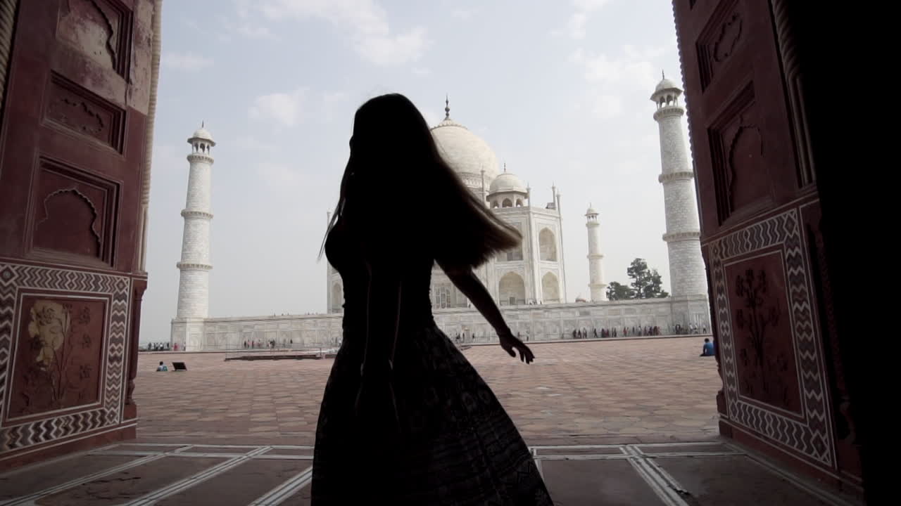 mujer vestida girando sobre sí misma con taj mahal en el fondo