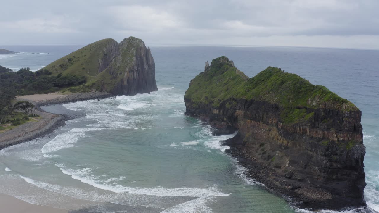 беспилотник летит сбоку к отверстию в стене и зеленым скалистым утесам в индейском океане, южная африка