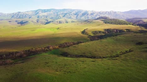 flying toward rolling california hills at sunrise