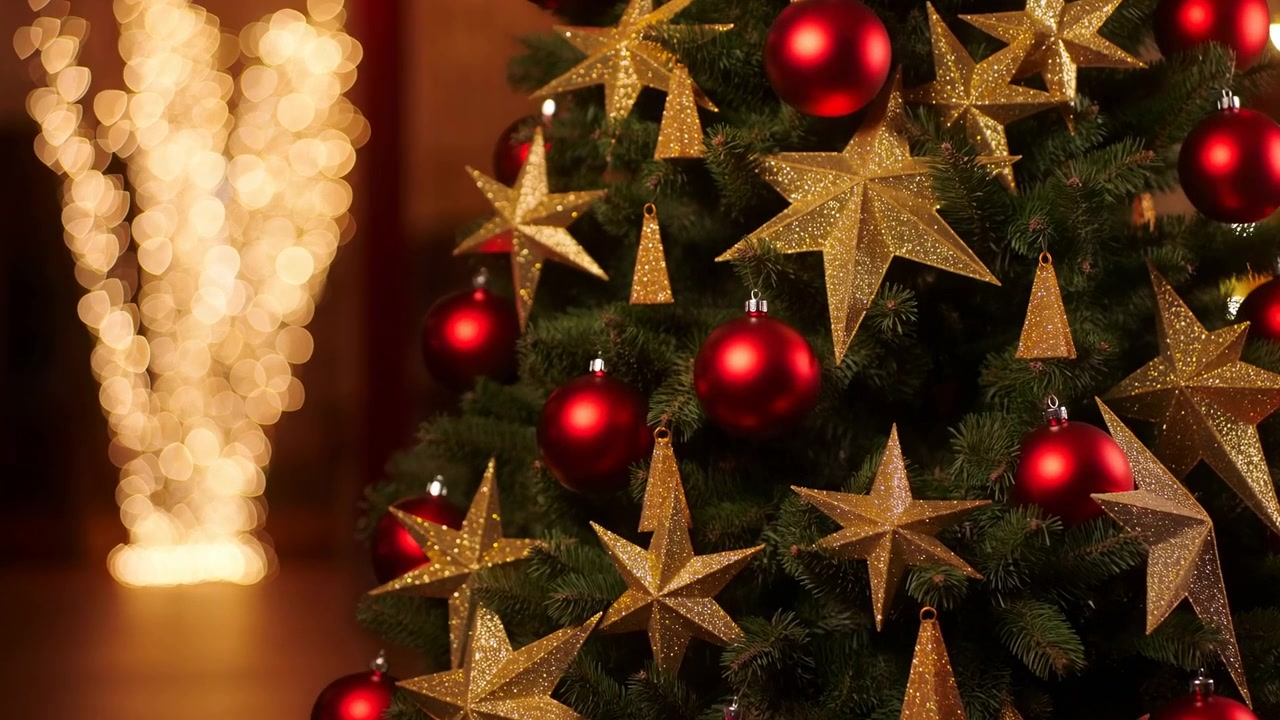Primo piano di albero di Natale decorato con bokeh dorato, palline rosse e stelle dorate scintillanti, luci interne calde