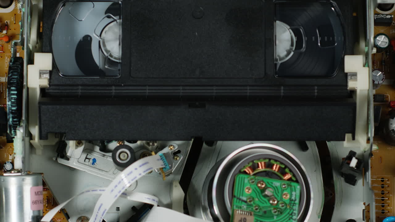 Old video recorder inside close-up, VHS. Retro player in neon blue light, vintage video cassette broadcasting, audio tape.