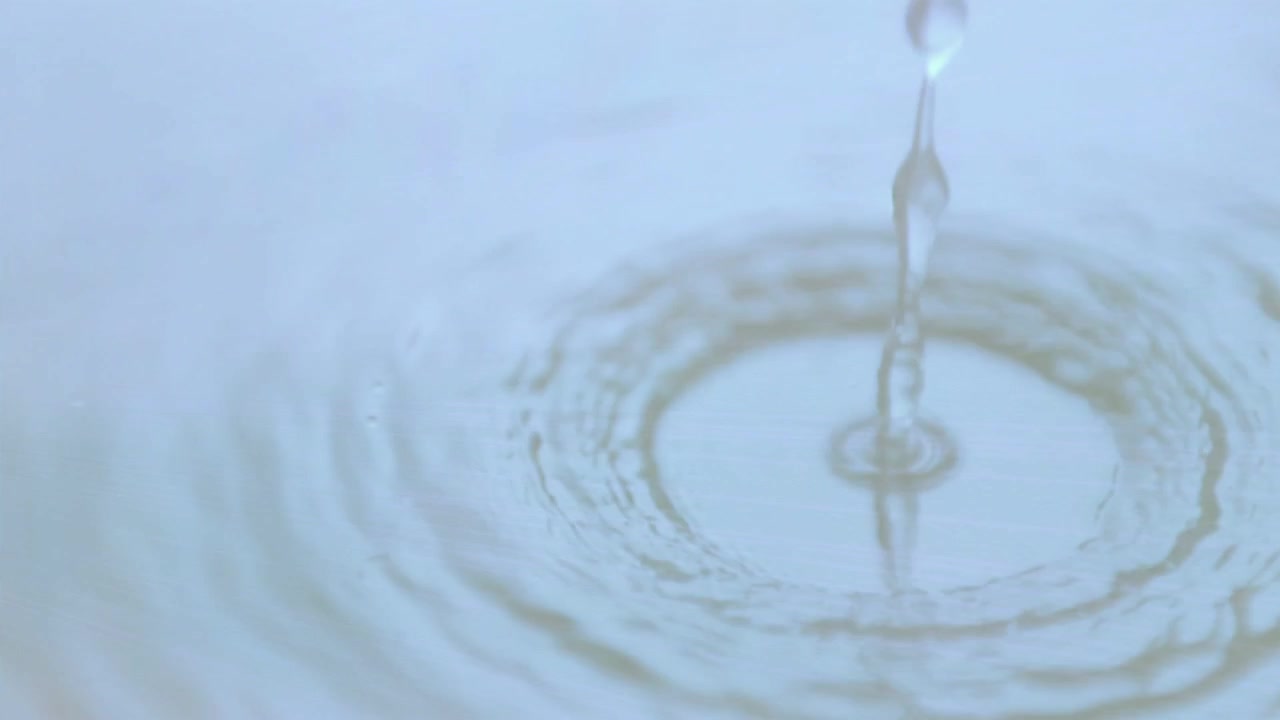 細い水流が狭まり、水滴が形成され、落下し、飛び散り、波紋を作り出すことで流体の動きを表現している。
