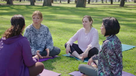 women friends enjoying a yoga session and conversation in a park