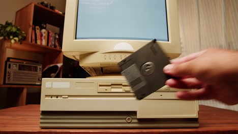 inserting a floppy disk into a vintage computer
