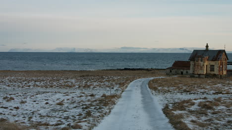 the camera pans, starting with the weathered house before revealing the endless ocean