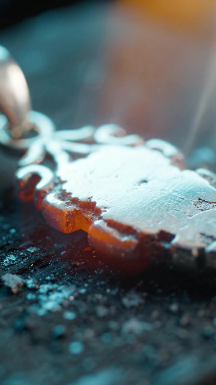 Un ciondolo elaborato con finitura scintillante: un primo piano della maestria artigianale e dei dettagli di un gioiello splendidamente disegnato che brilla sotto la luce.