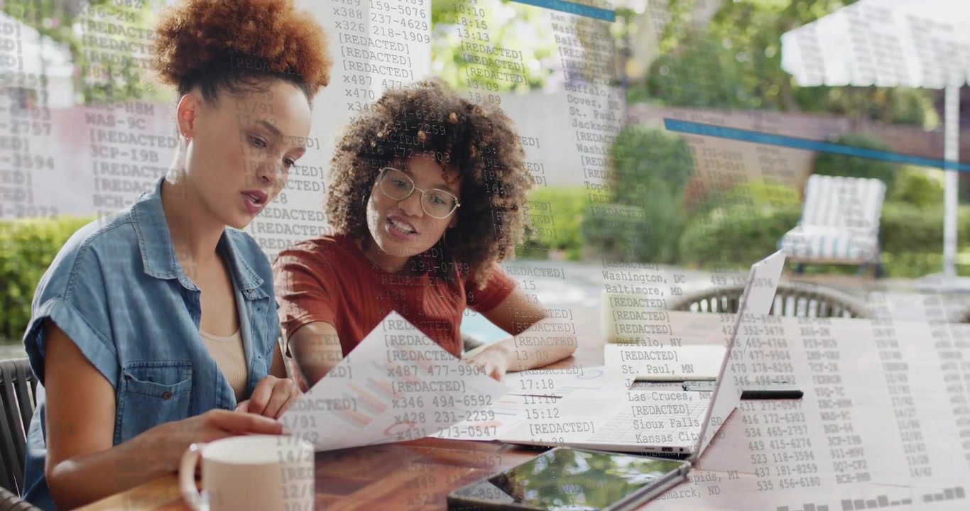 Two colleagues pointing to financial charts on patio, showing floating numerical data for insights