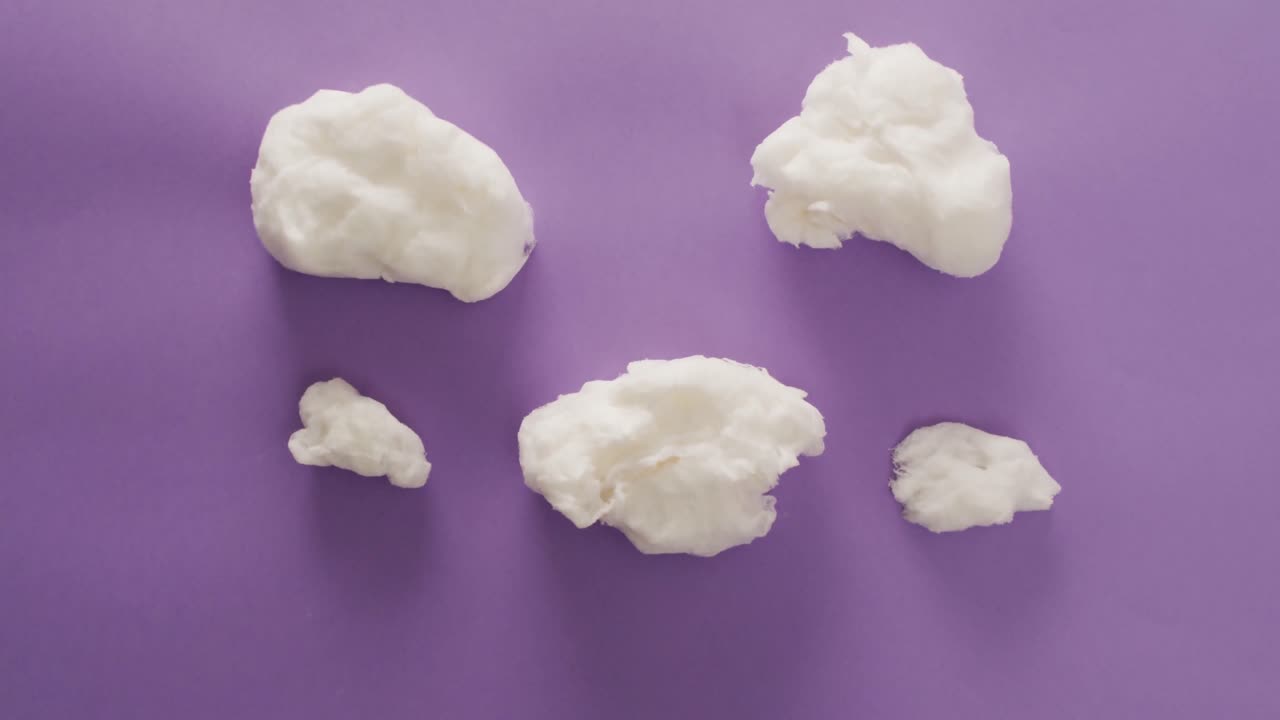 video de trozos de malvaviscos tirados en una superficie púrpura